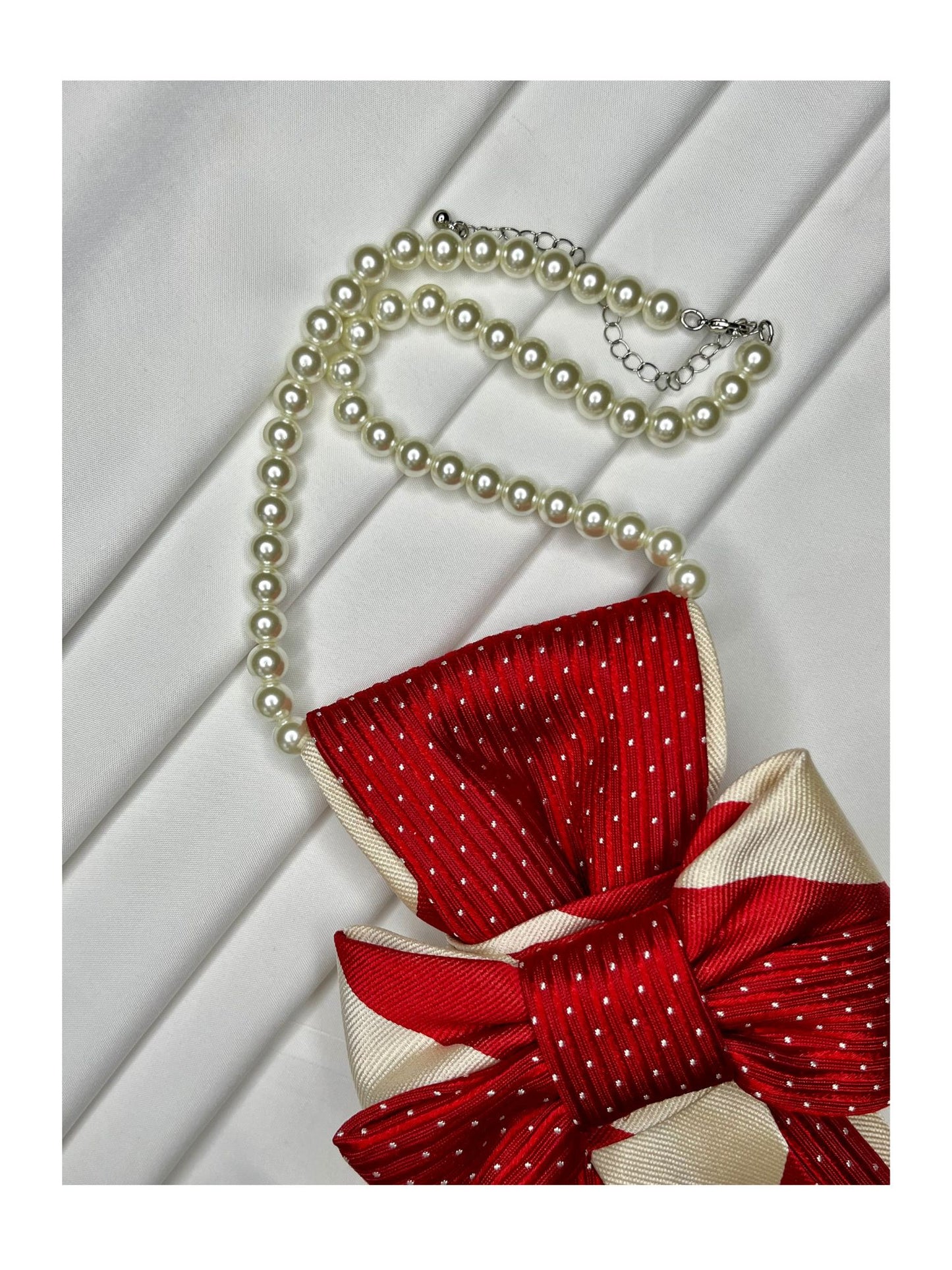 Närbild på röd julslipsrosett med vita diagonala detaljinslag