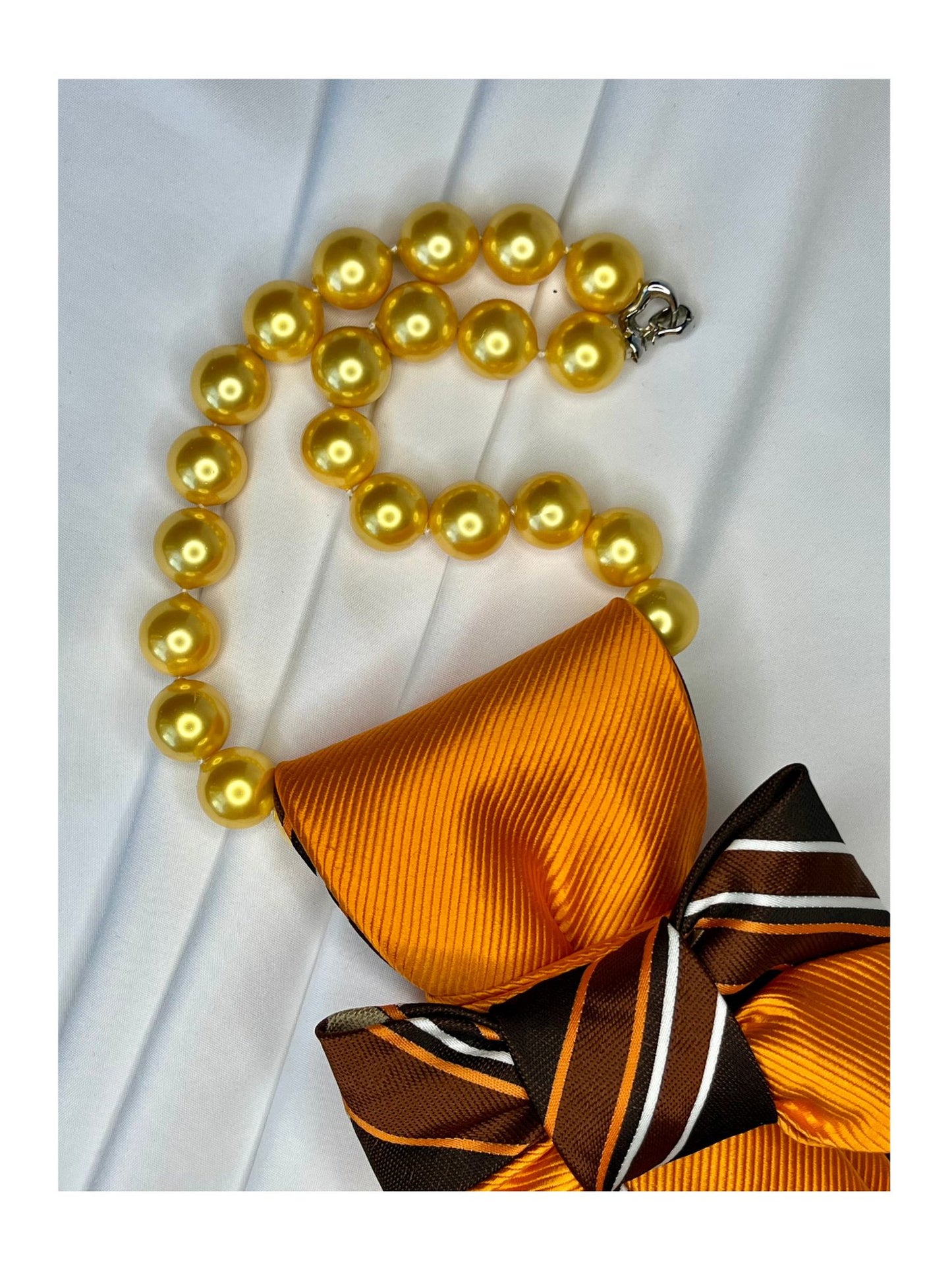 Närbild av halsband för handgjord slipsrosett i brons, choklad och guldorange