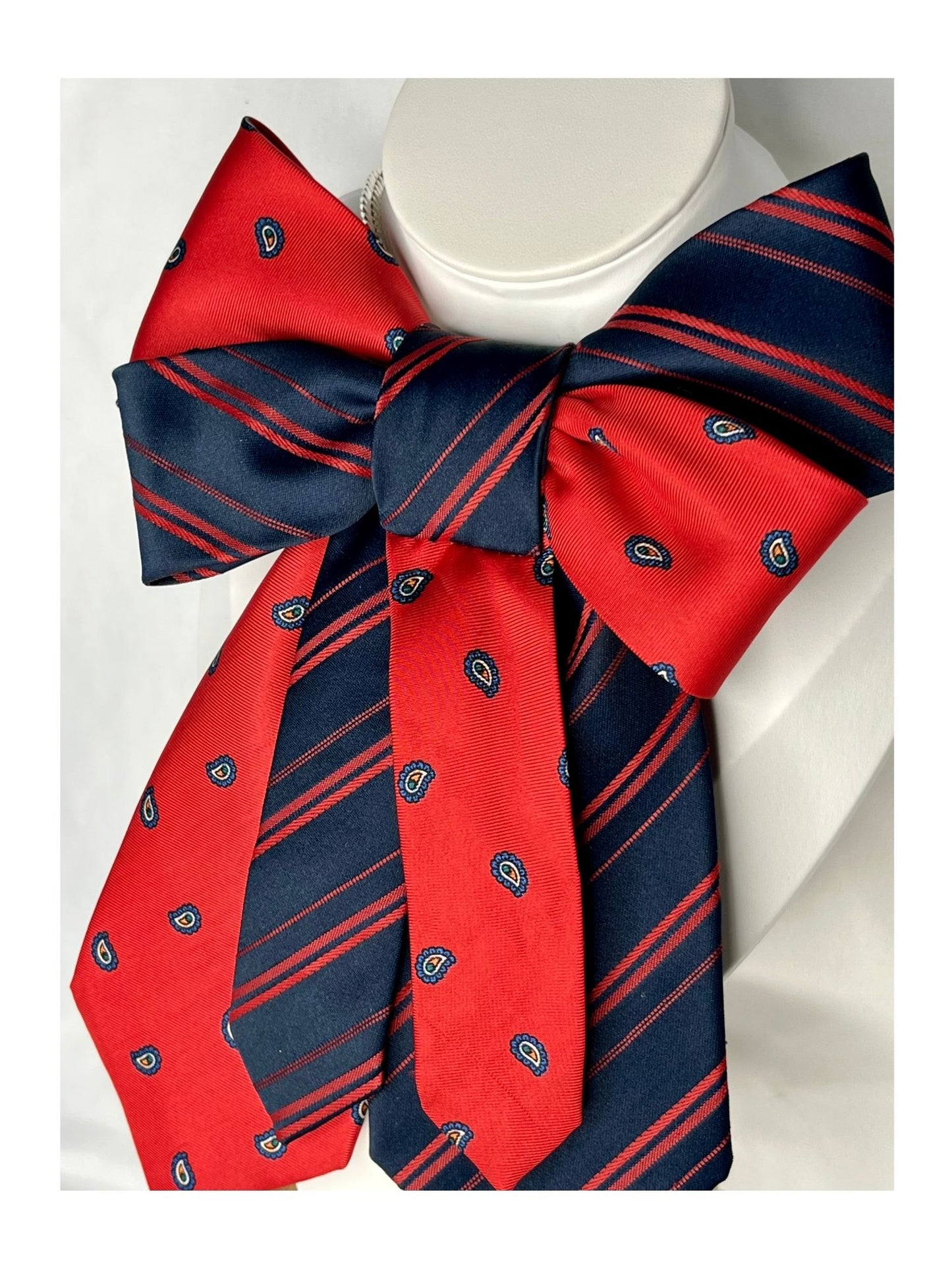 Sidovy och närbild av handgjord festlig slipsrosett i rött och marinblått med ett stilrent mönster 