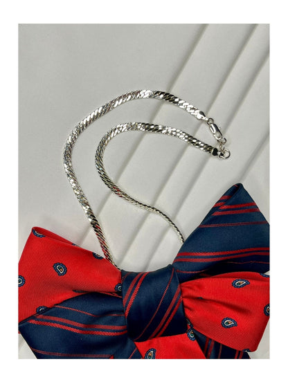 Närbild av halskedja för handgjord festlig slipsrosett i rött och marinblått med ett stilrent mönster 