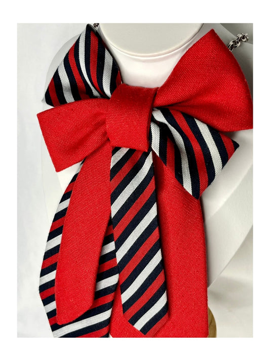 Sidovy och närbild av handgjord slipsrosett i klar röd ton med klassiska ränder som för tankarna till fest, värme och vinterfirande