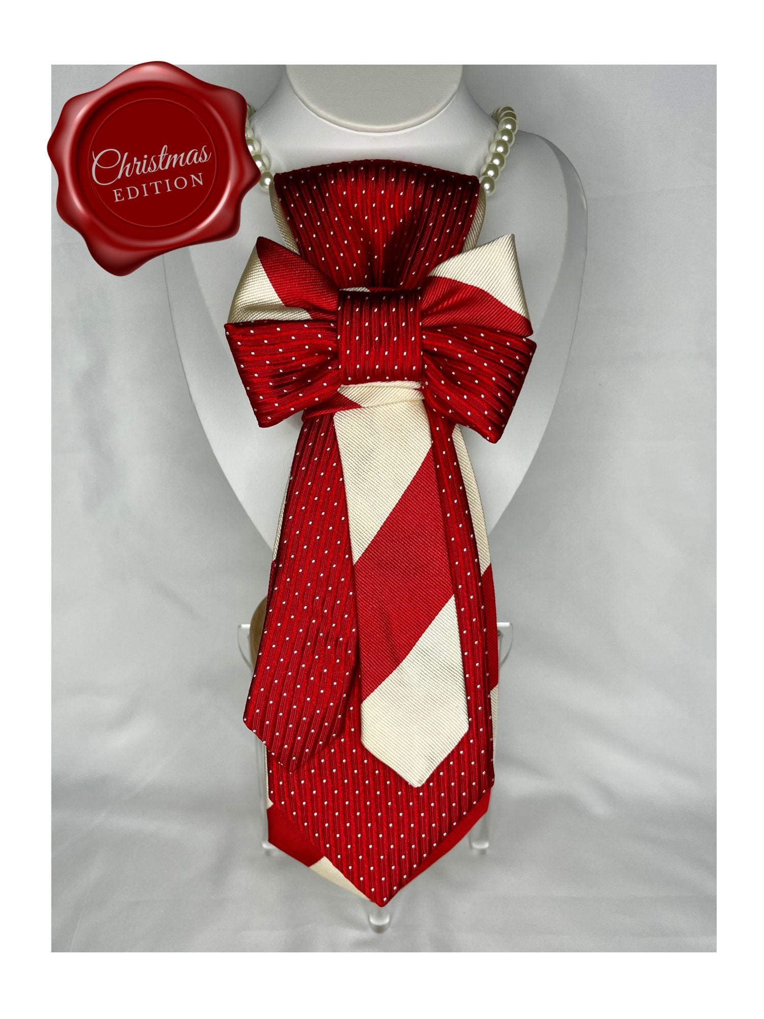 Röd handgjord julslipsrosett med vita detaljer fotograferad framifrån i helvy