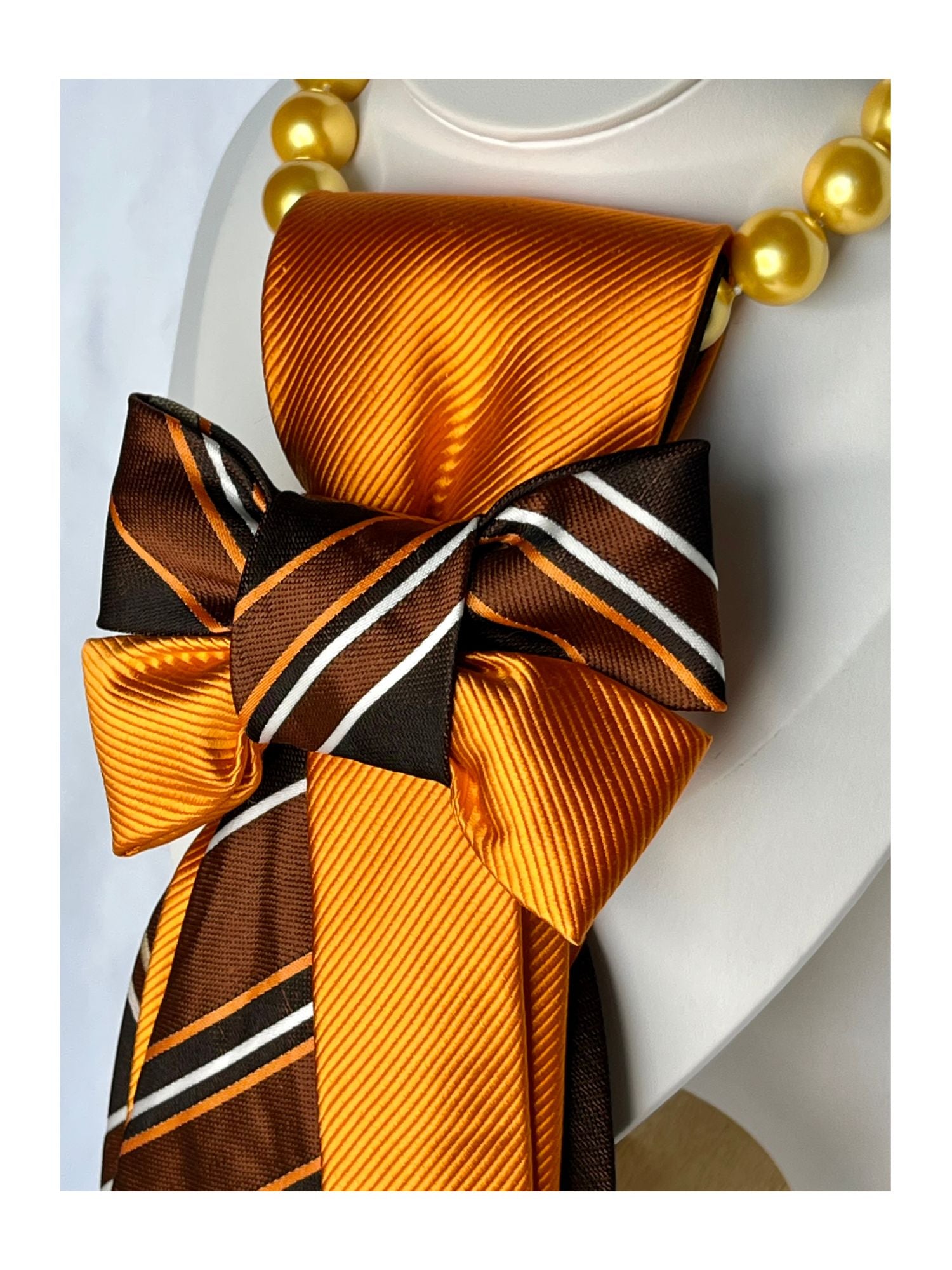Sidovy och närbild av handgjord slipsrosett i brons, choklad och guldorange