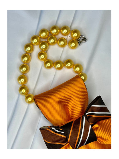 Närbild av halsband för handgjord slipsrosett i brons, choklad och guldorange