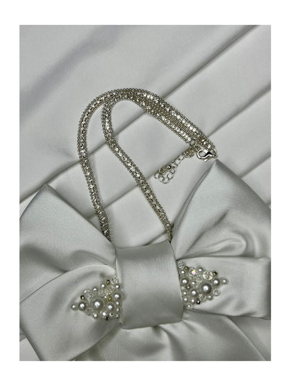 Närbild av halskedja för handgjord slipsrosett vit ton med pärldetaljer