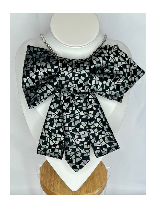 Bild framifrån av flugrosett i svart med grafiskt, mosaikliknande mönster