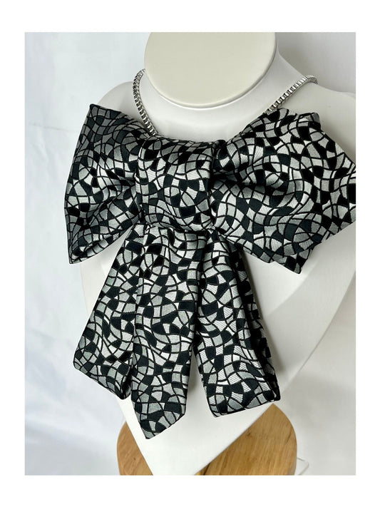 Snett framifrån av flugrosett i svart med grafiskt, mosaikliknande mönster