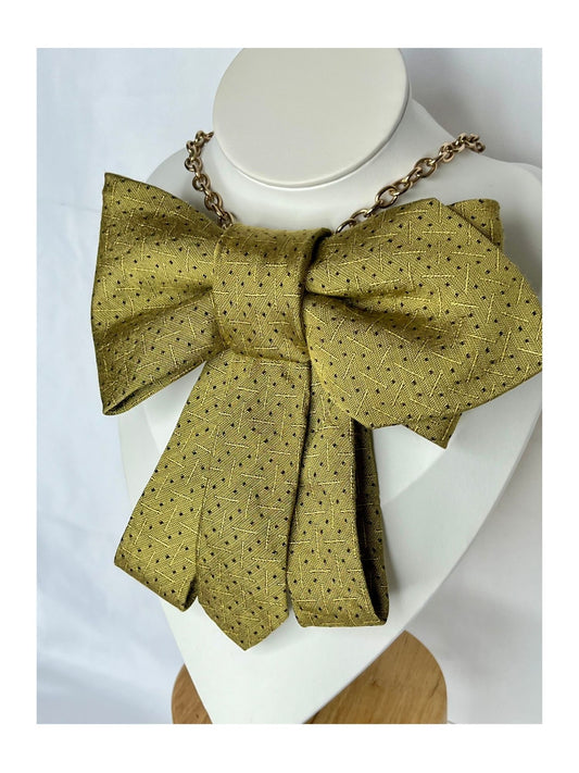 Snett framifrån av flugrosett i varm gyllengul ton med diskret prickmönster