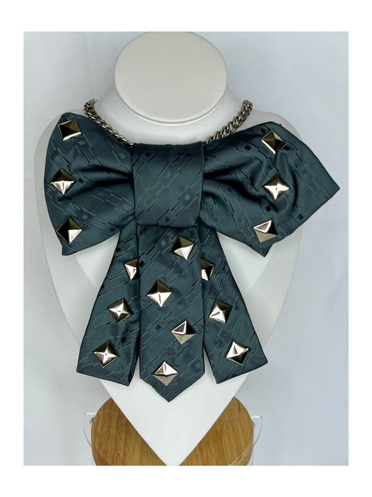 Bild framifrån av slipsrosett i petrolgrön ton med markerade nitar och dekorativ kedja