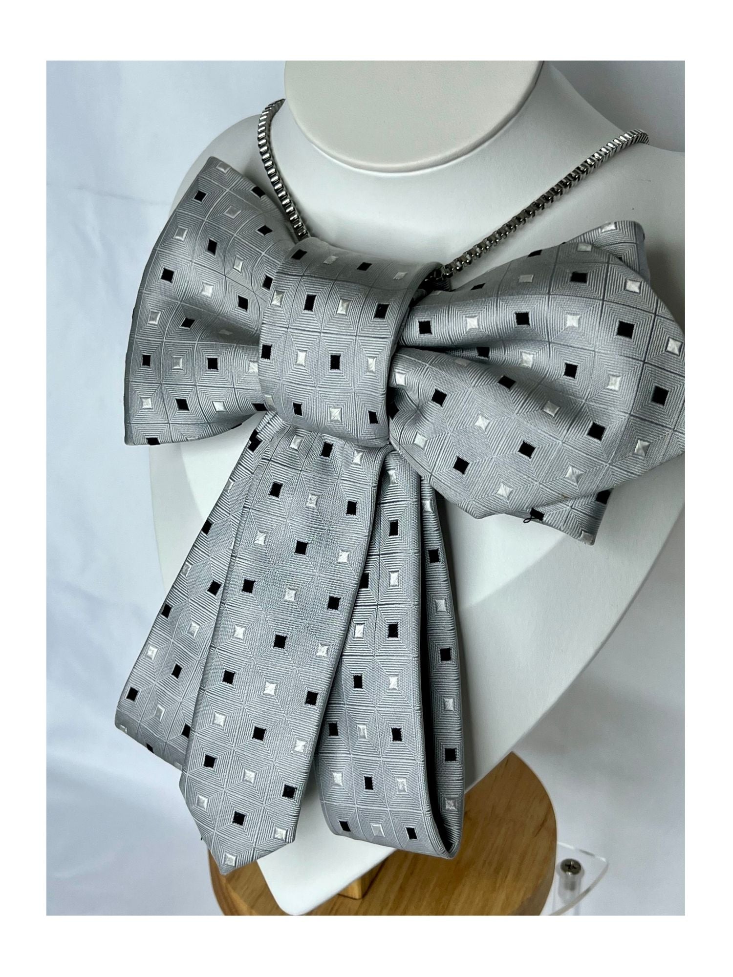 Närbild från sidan av flugrosett i silvergrå ton