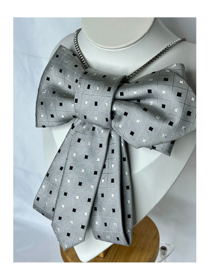 Närbild från sidan av flugrosett i silvergrå ton